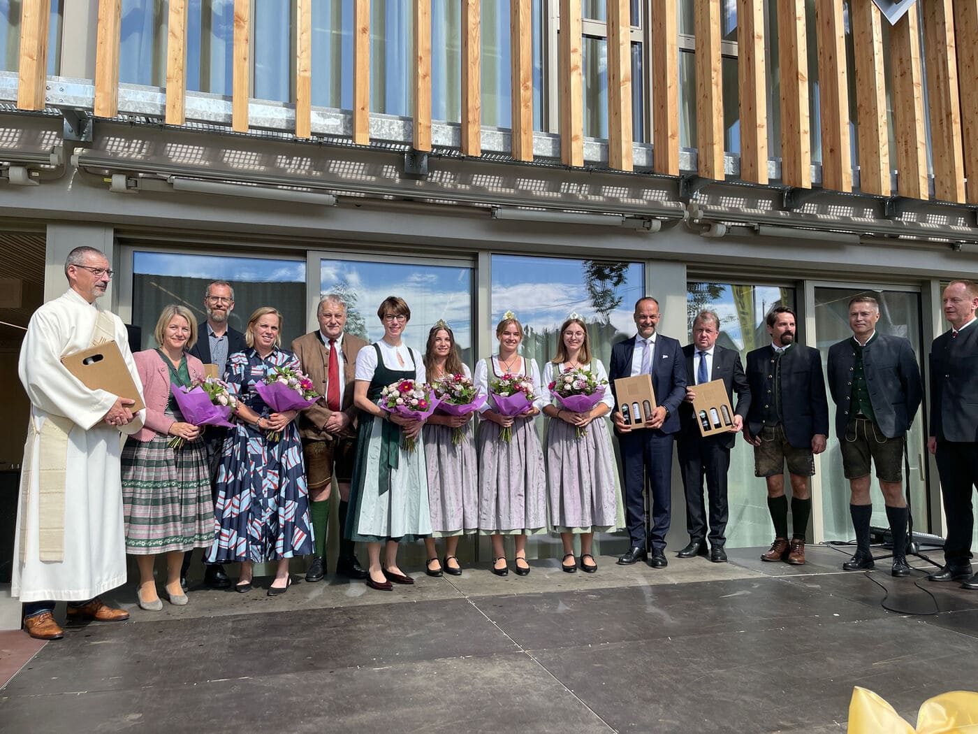 Ehrengäste und Weinhoheiten bei der Eröffnung der Raiffeisenbank Gamlitz vor der Holzfassade des Zubaus